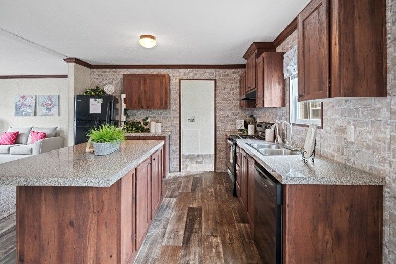 A kitchen with dark wood cabinets, a large island, and a light-colored countertop. The flooring and backsplash have a stone-like appearance.