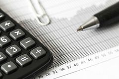 a close up of a calculator and pen and paper document