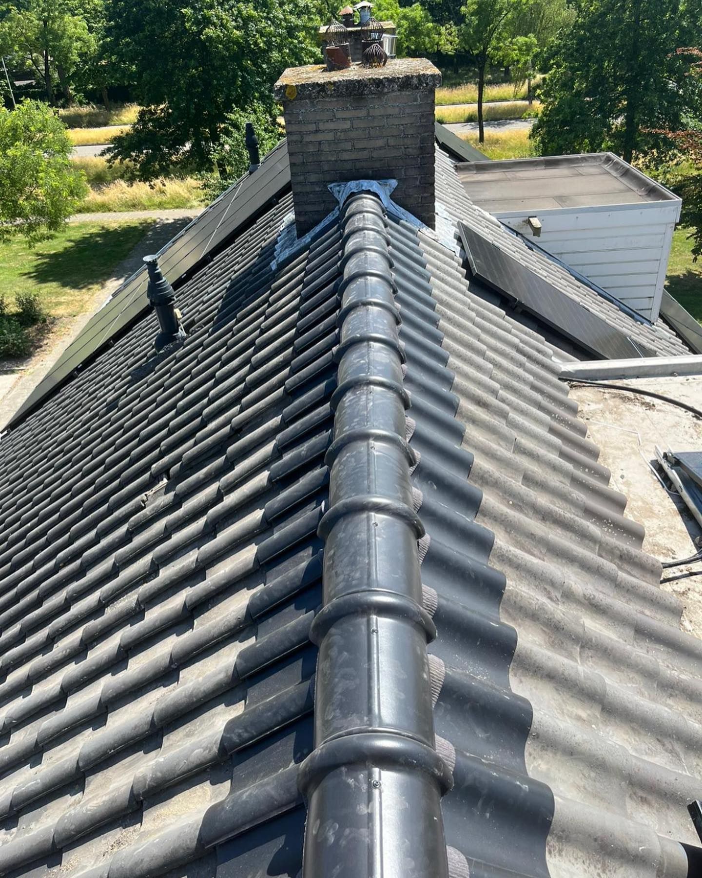 het dak van een huis met daarop een schoorsteen.