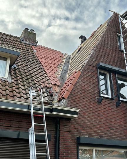 een man werkt op het dak van een bakstenen gebouw.