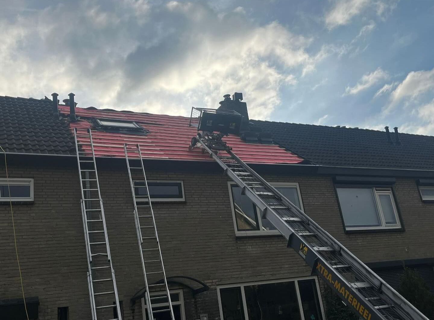 een groep mensen werkt op het dak van een huis.