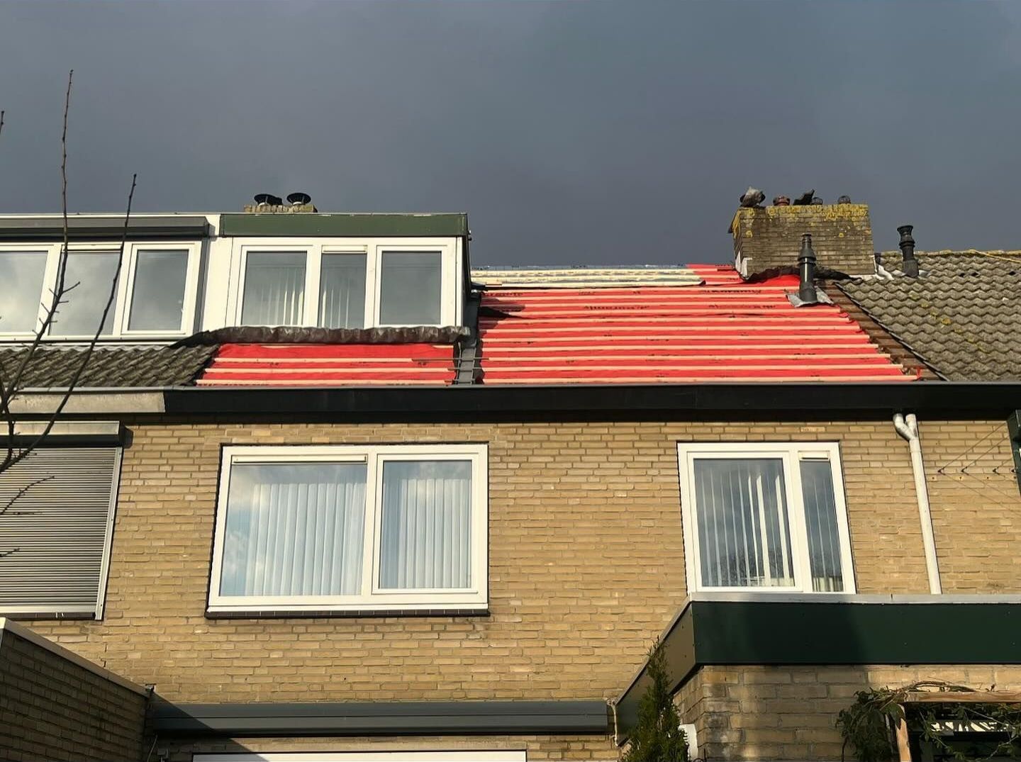 het dak van een huis wordt rood geverfd