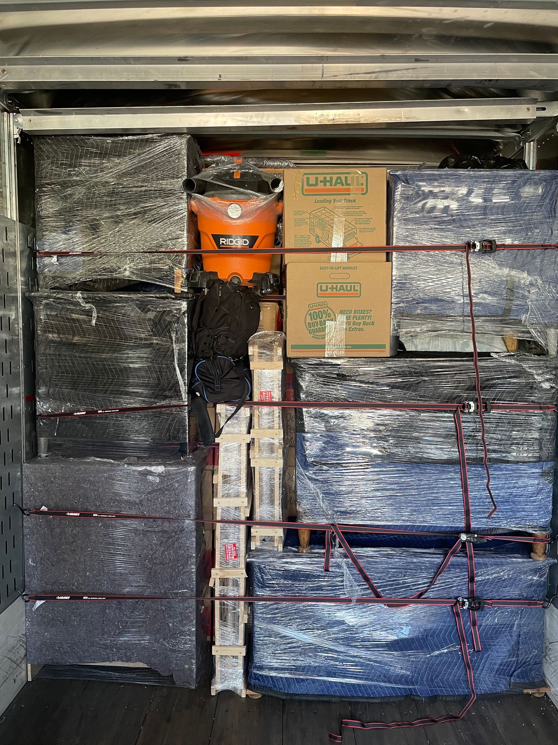 A truck filled with boxes and a vacuum cleaner.