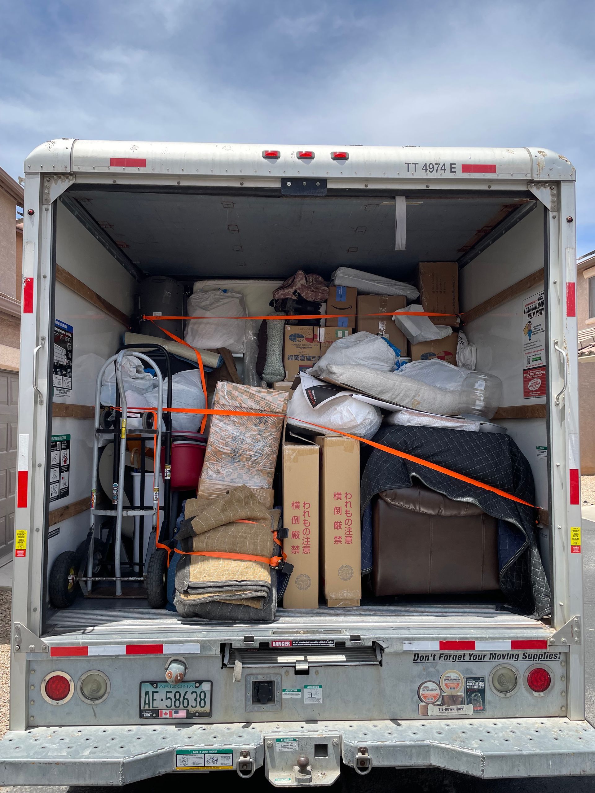 The back of a moving truck filled with boxes and furniture.