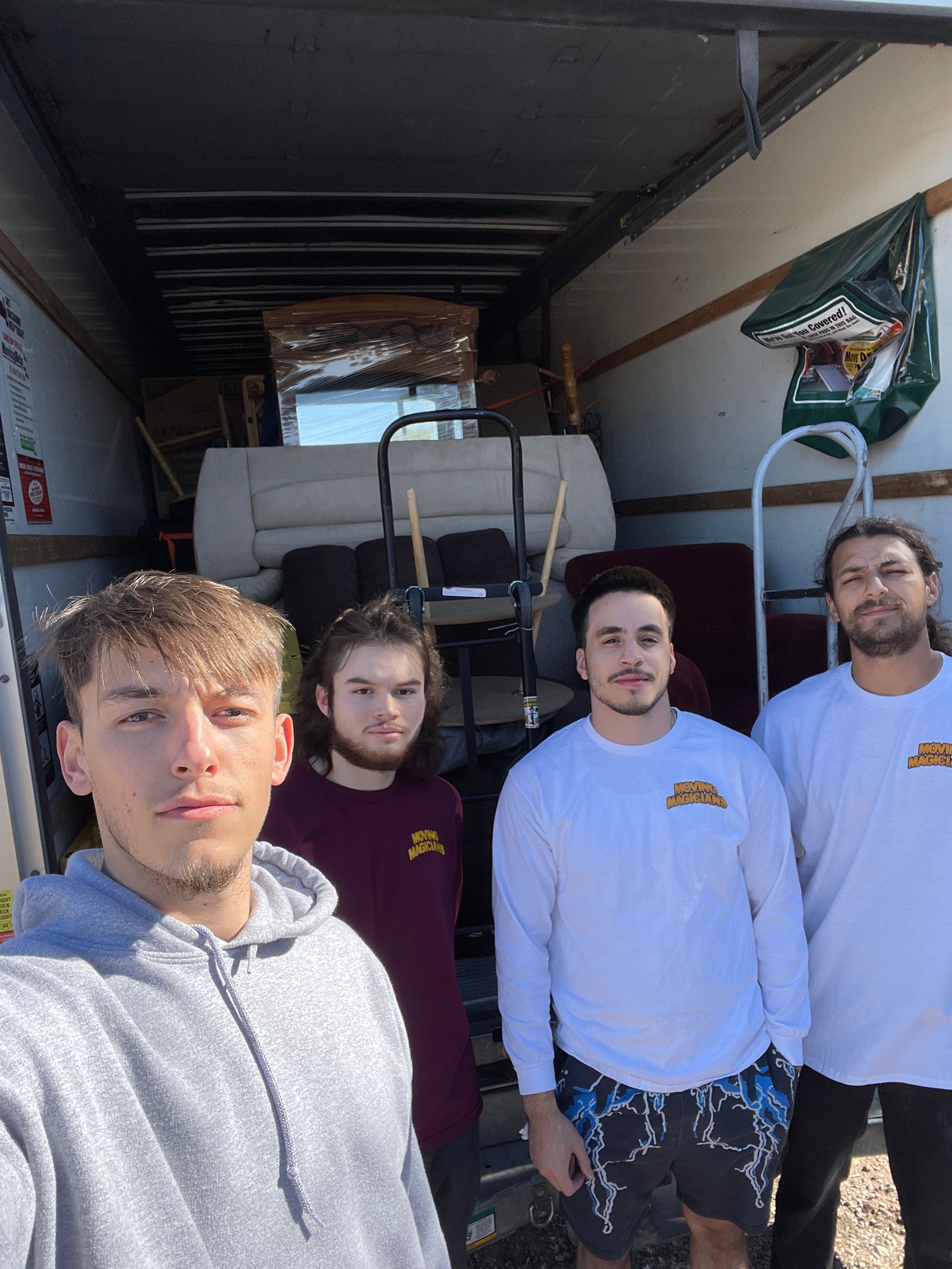 A group of young men are standing in front of a truck.