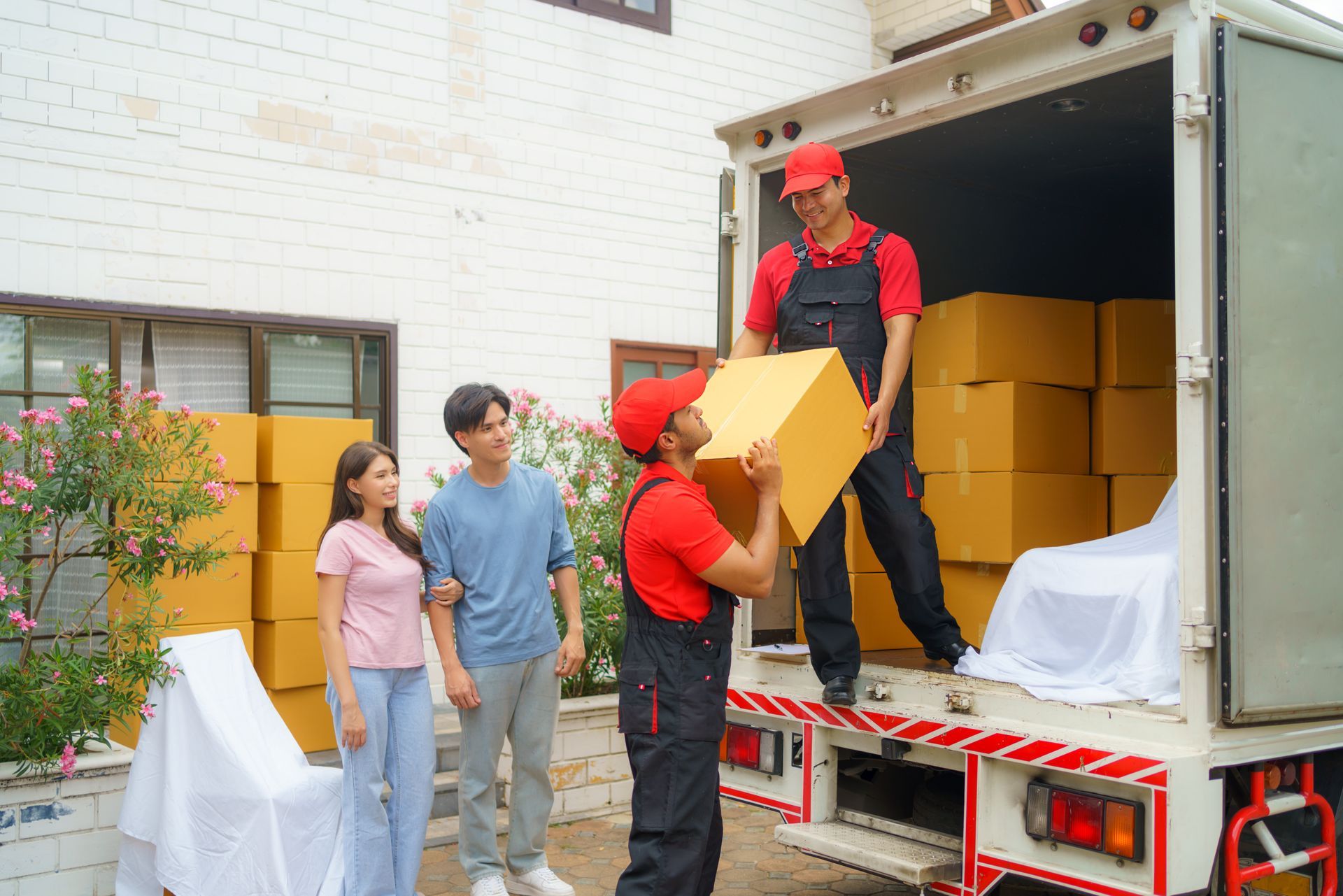 A group of people are standing in front of a moving truck.