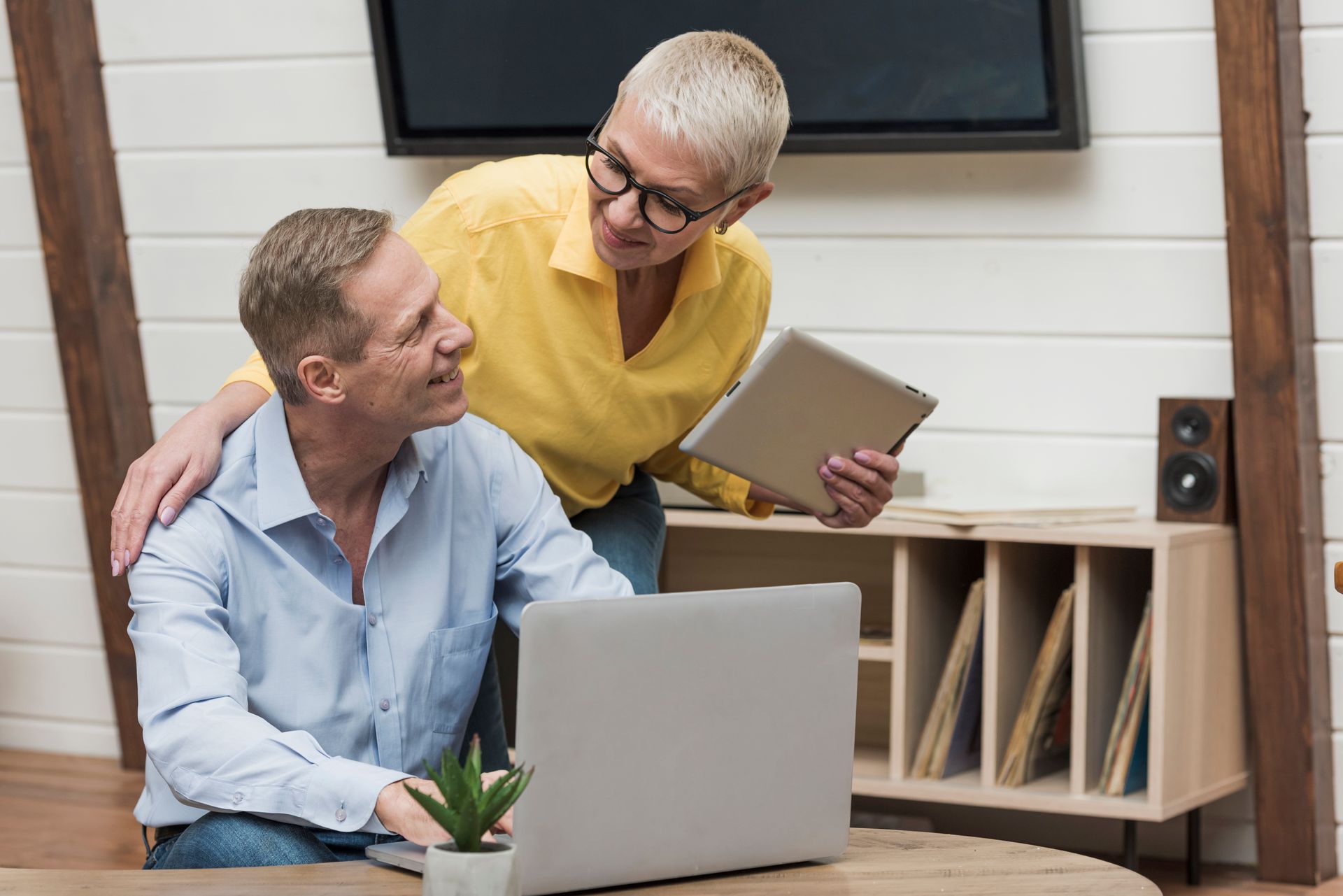 A man and a woman are looking at a laptop computer.