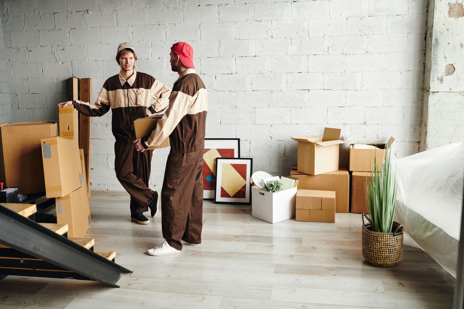 Two men are standing in a room filled with boxes.