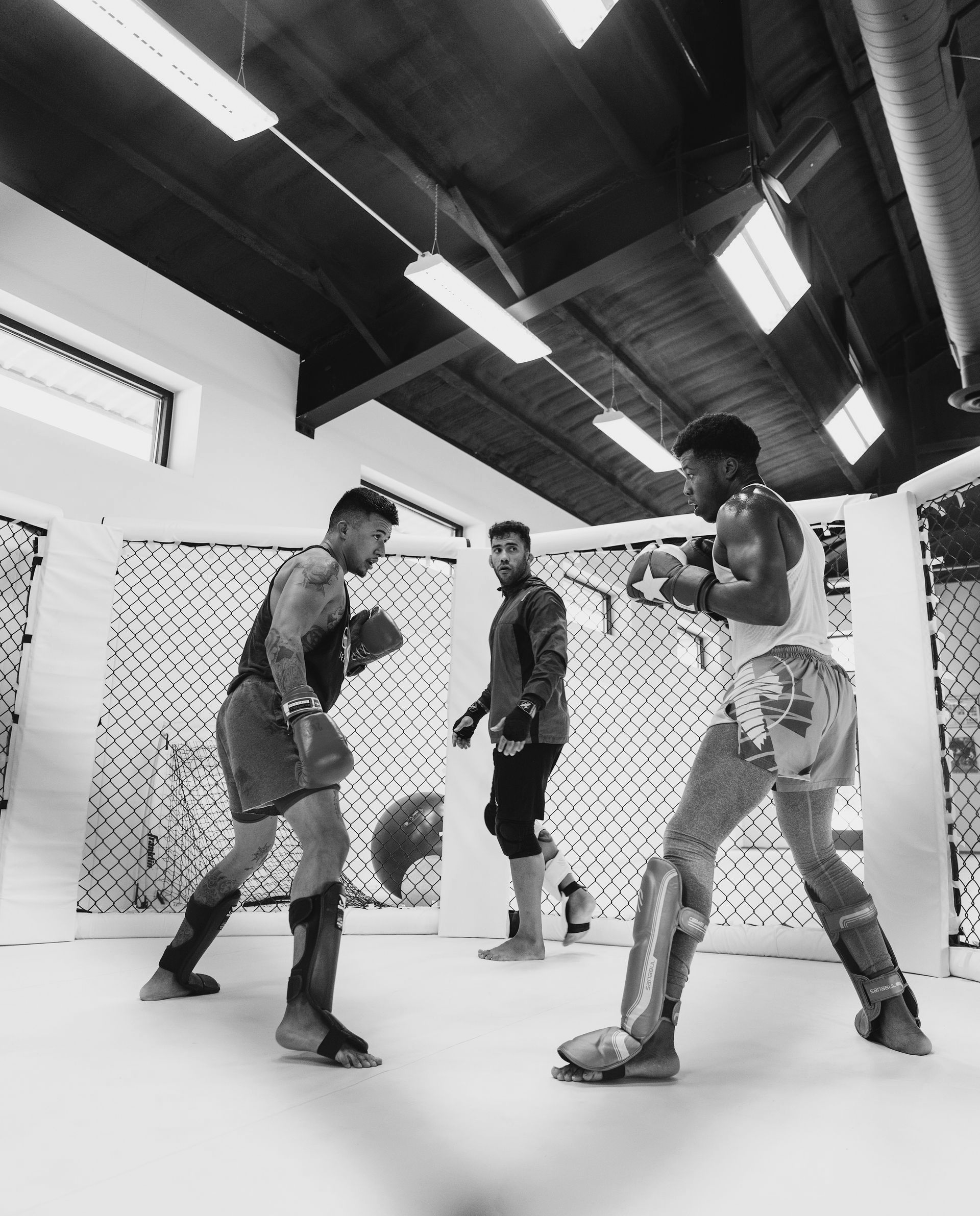 A man in a BJJ gi is teaching a group of children.