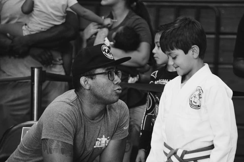 A coach instructing a young martial artist.