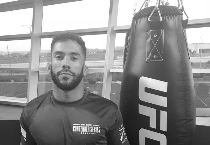 Man standing near a UFC punching bag