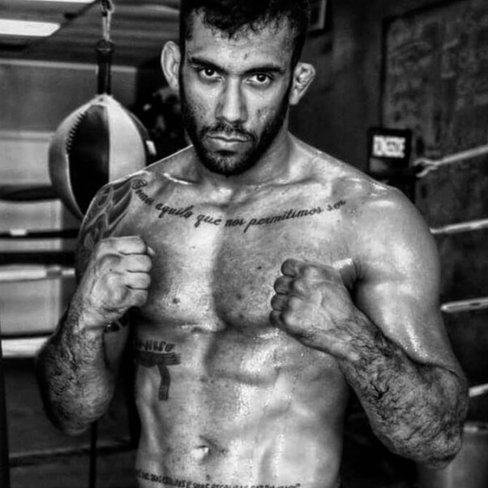 A man with a beard wearing boxing gloves.