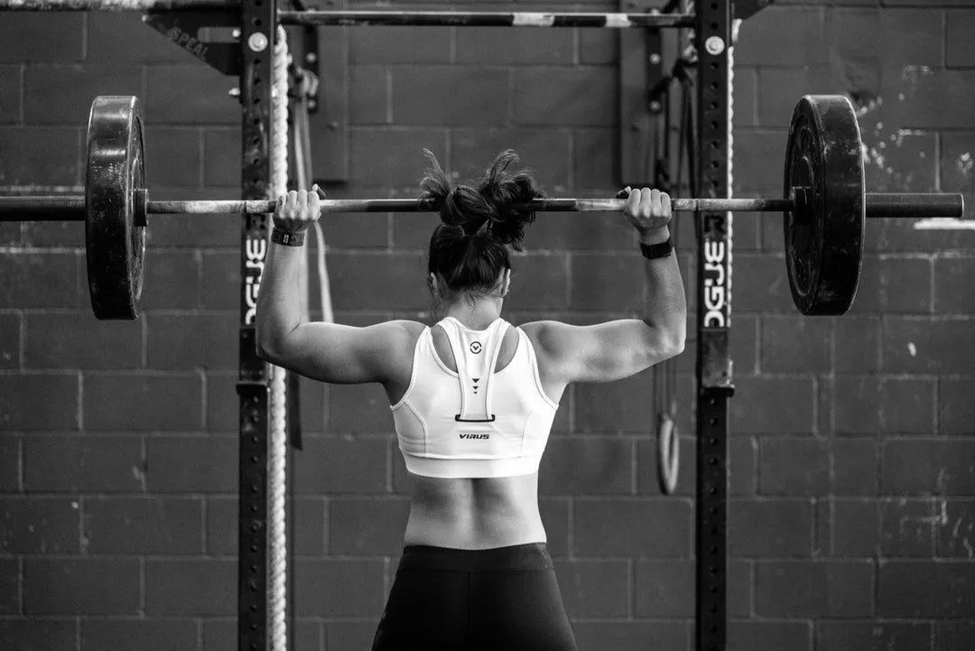 A woman lifting weights in a gym.