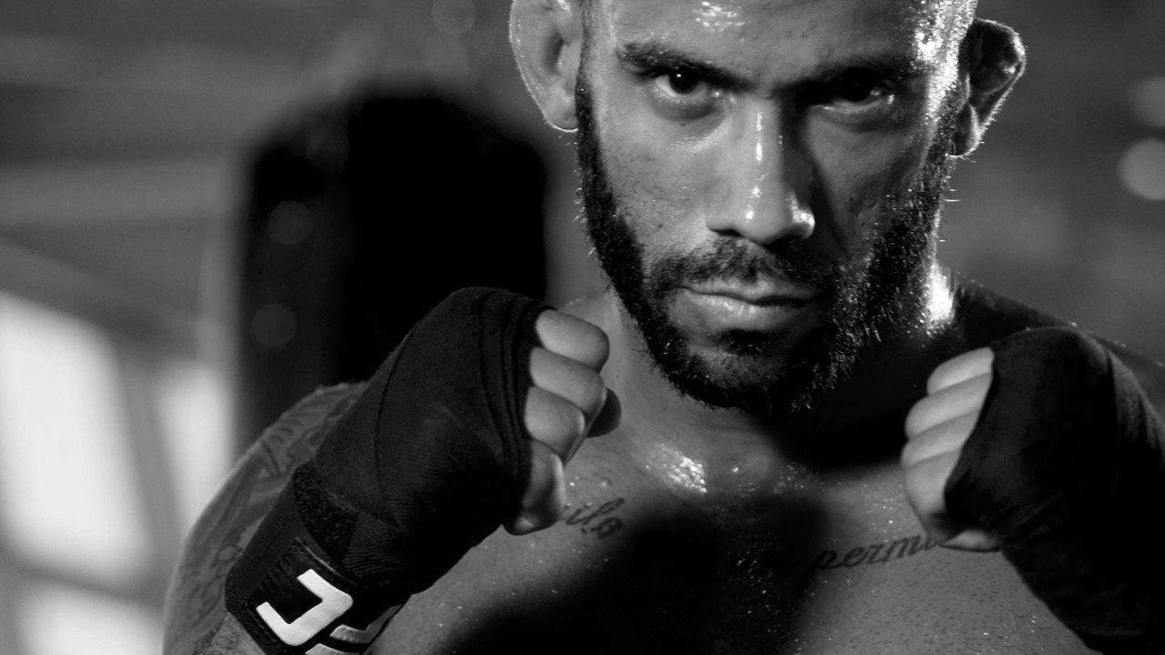 A bearded man stands in a fighting pose.