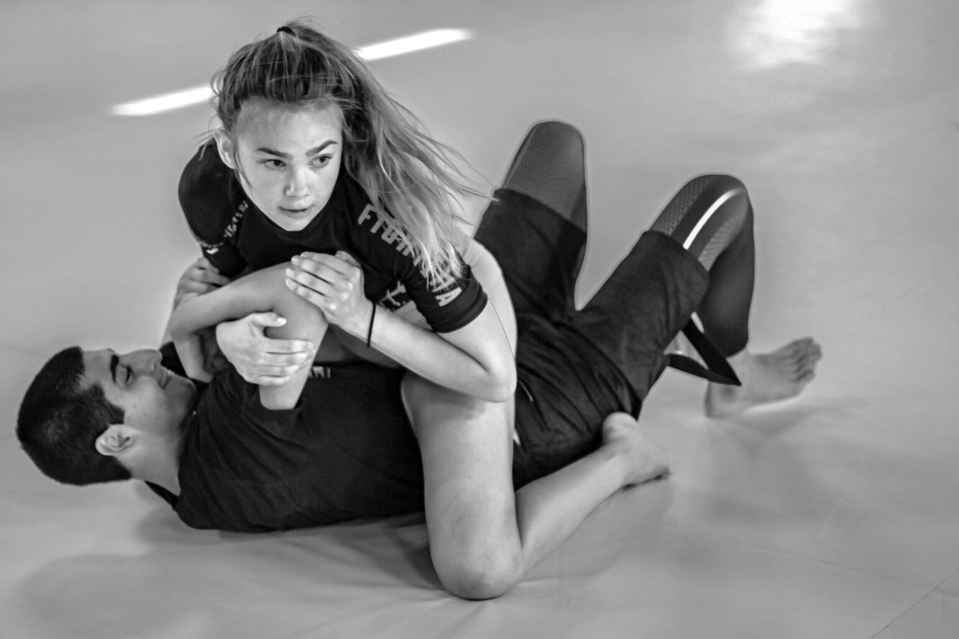 A girl has taken down another competitor in Brazilian Jiu-Jitsu practice.
