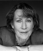 Ein Schwarzweißfoto einer lächelnden Frau, die sich auf ihren Ellbogen stützt.