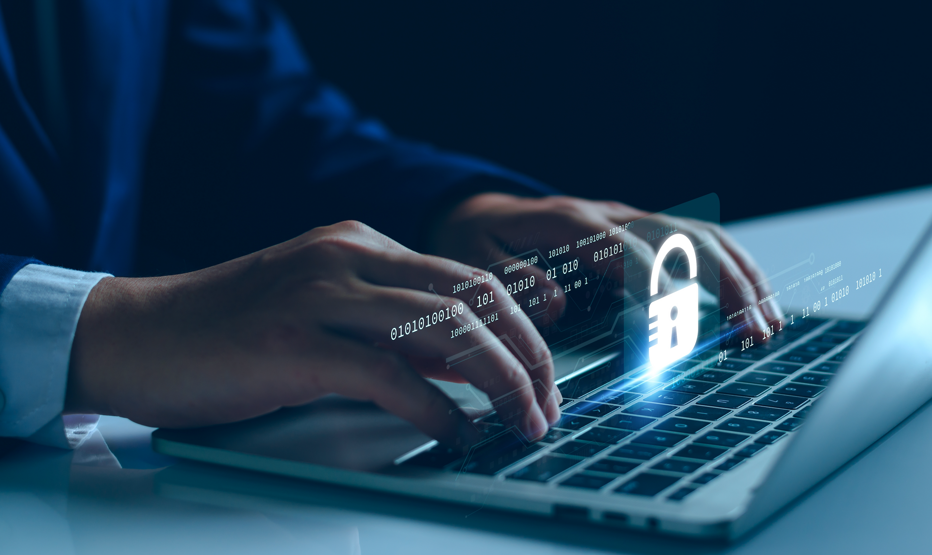 A person is typing on a laptop computer with a padlock coming out of the keyboard.