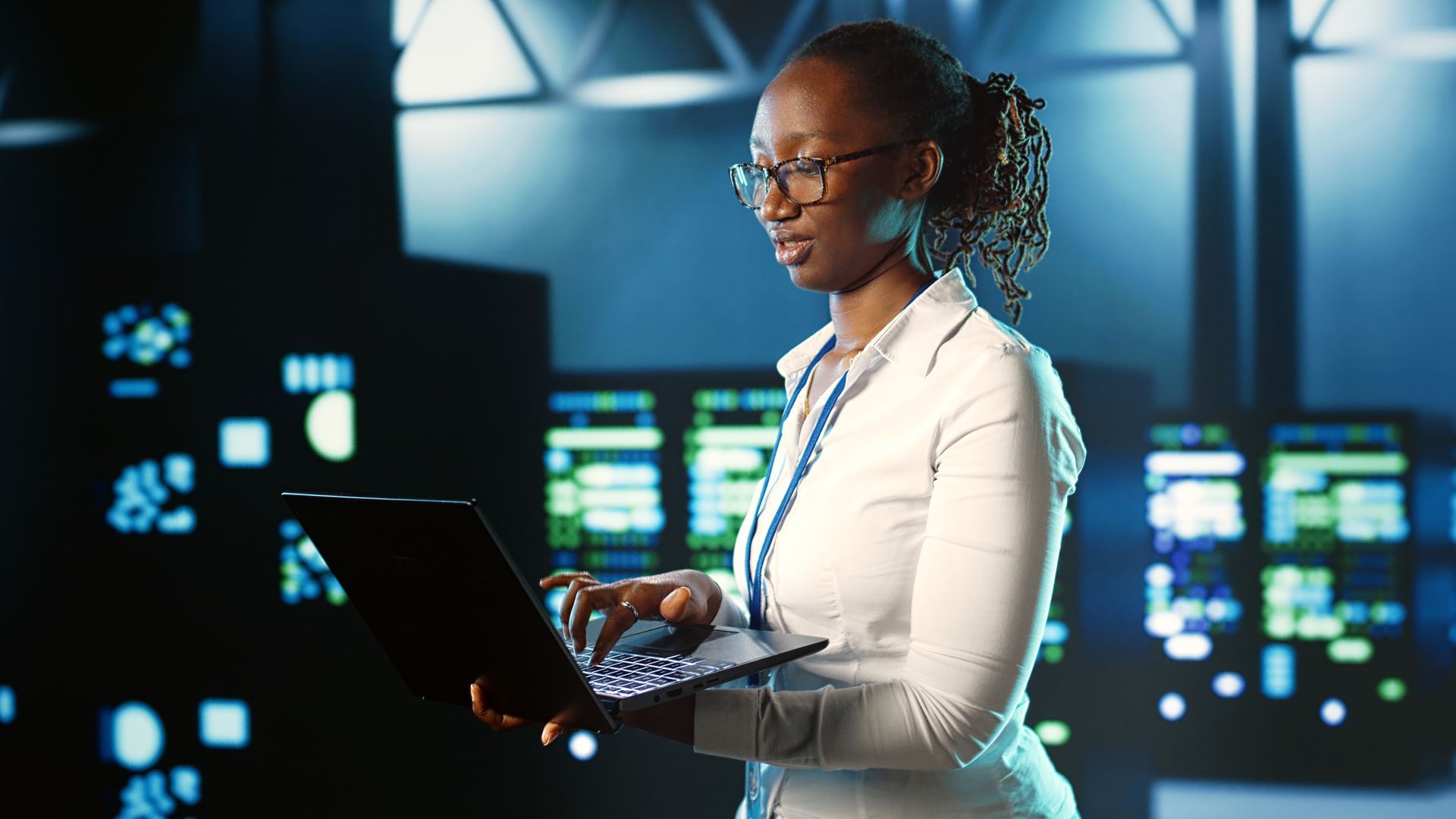 A woman is using a laptop computer in a dark room.
