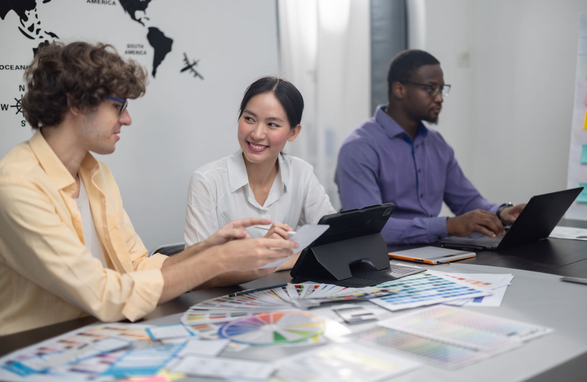 A group of people are sitting at a table with laptops.