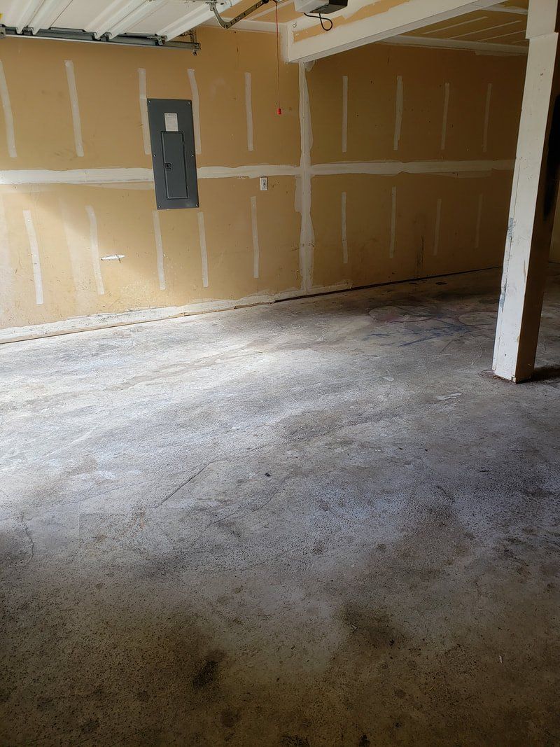 An empty garage with a concrete floor and walls.