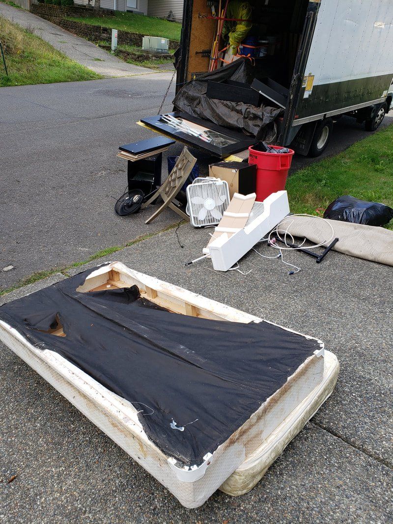 A mattress is sitting on the sidewalk next to a truck.