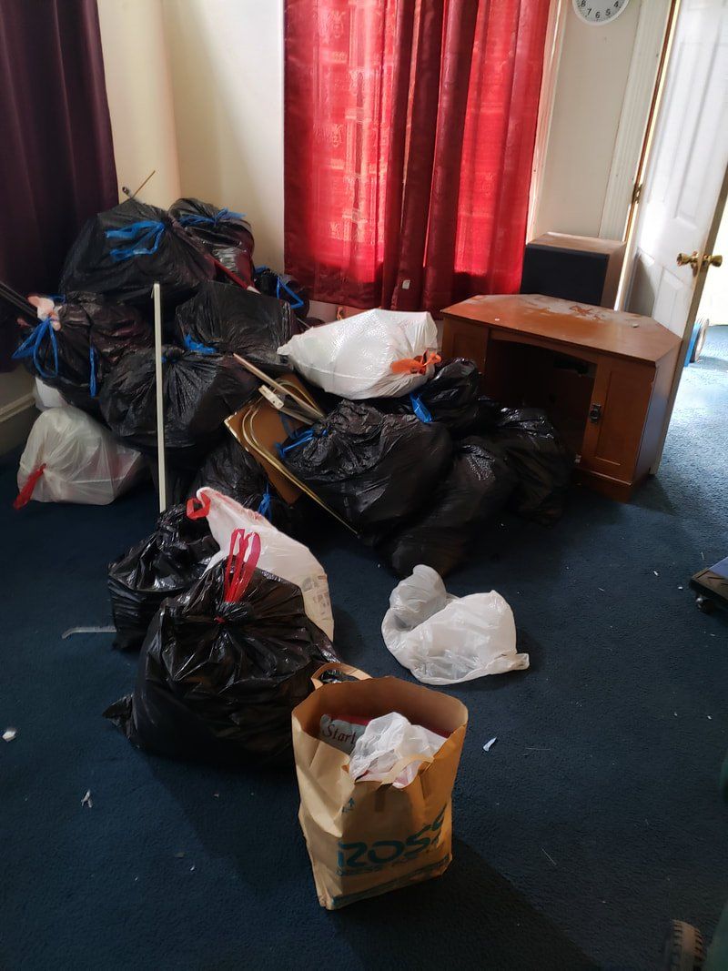 A room filled with lots of trash bags and a trash can.