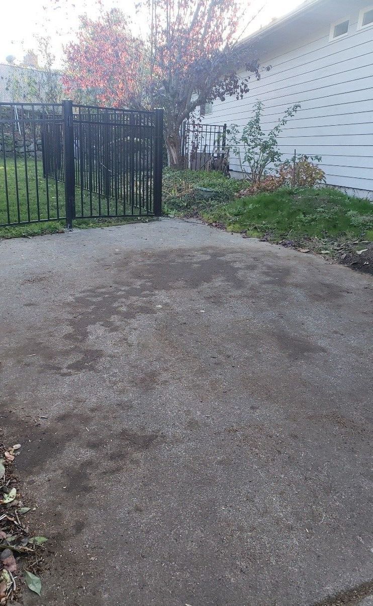 A backyard with a wooden fence and concrete blocks in the grass.