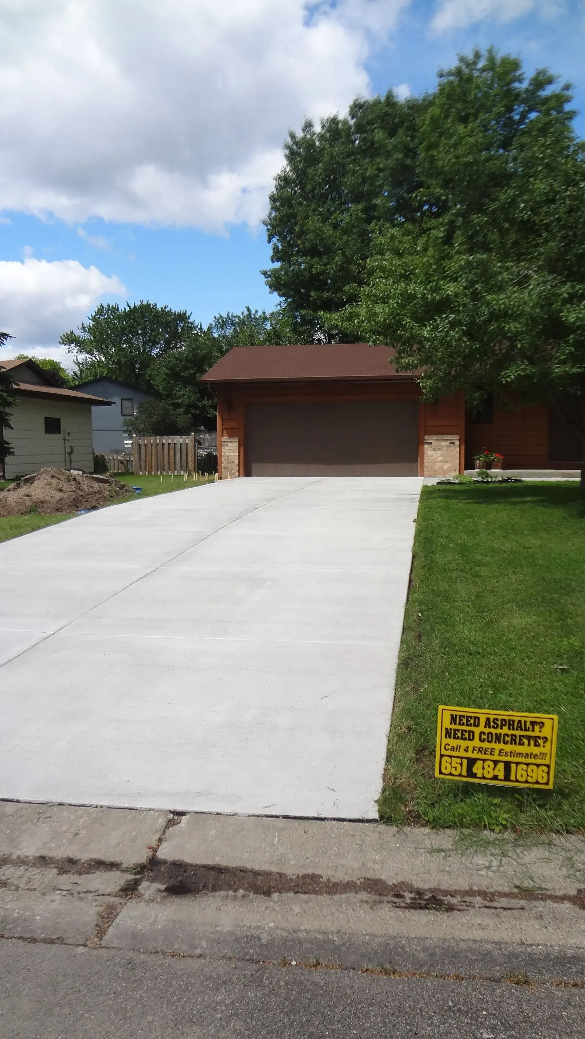 Empty, bright garage with two closed garage doors, a side door, and overhead garage door openers.