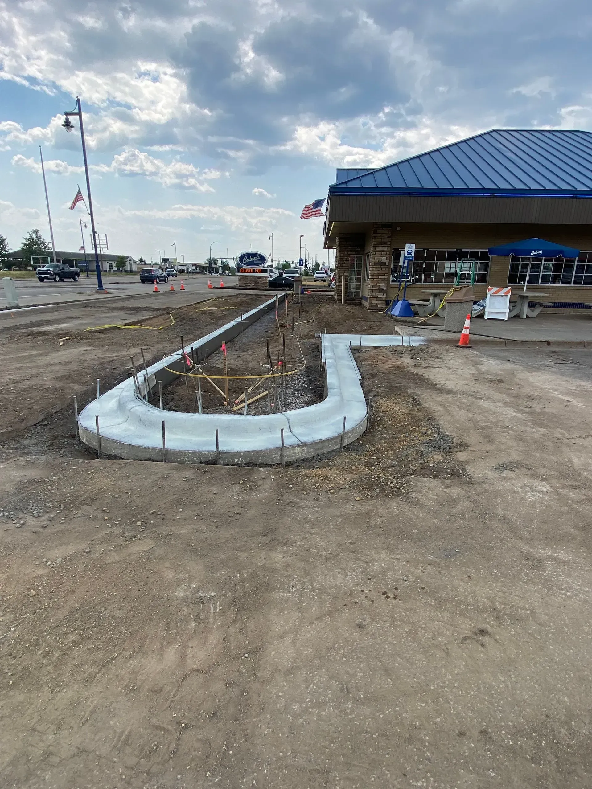 Exterior view of a Food Market, red brick facade, large windows, empty parking lot.