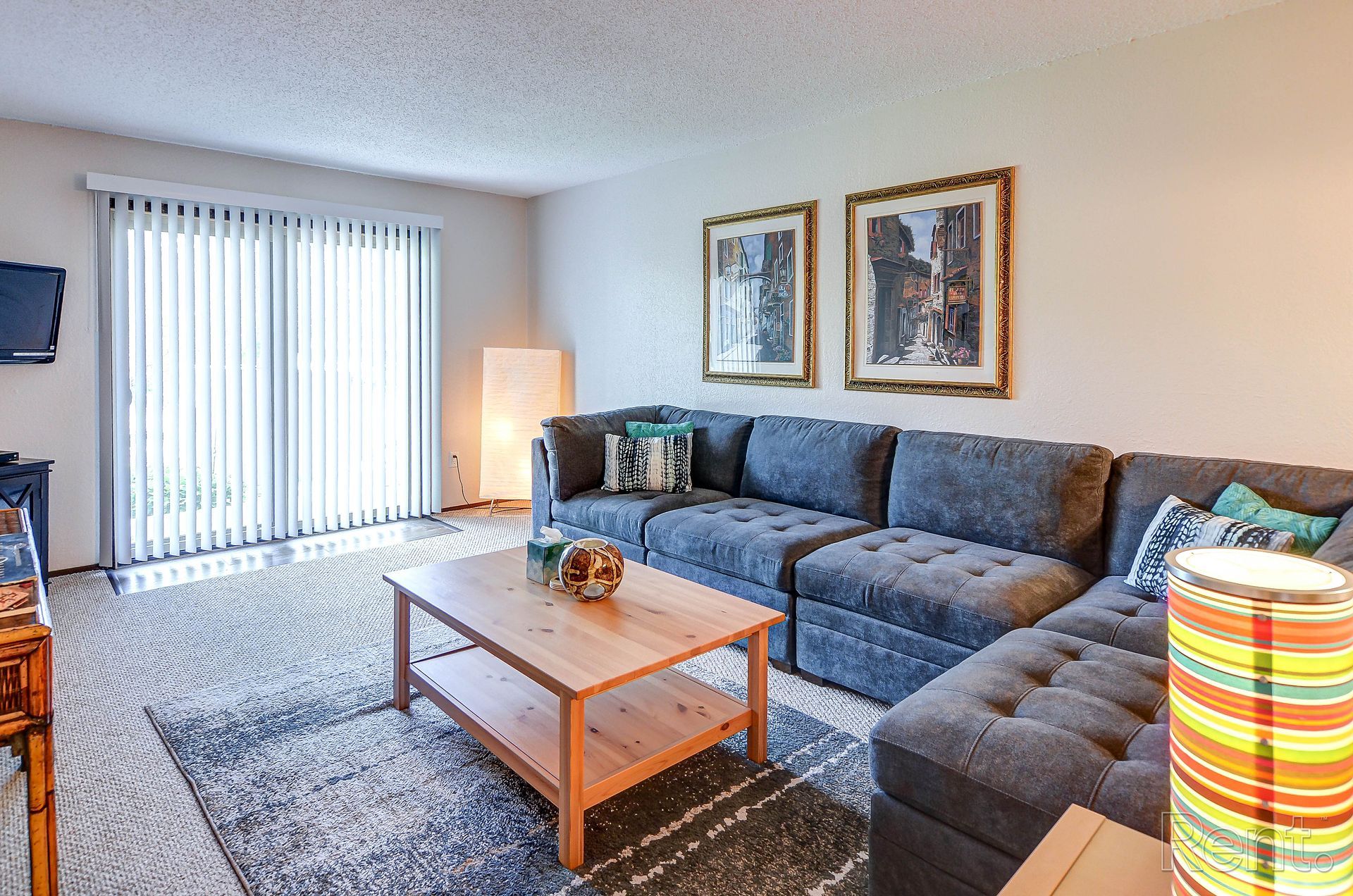 a living room with a couch , coffee table , and television .