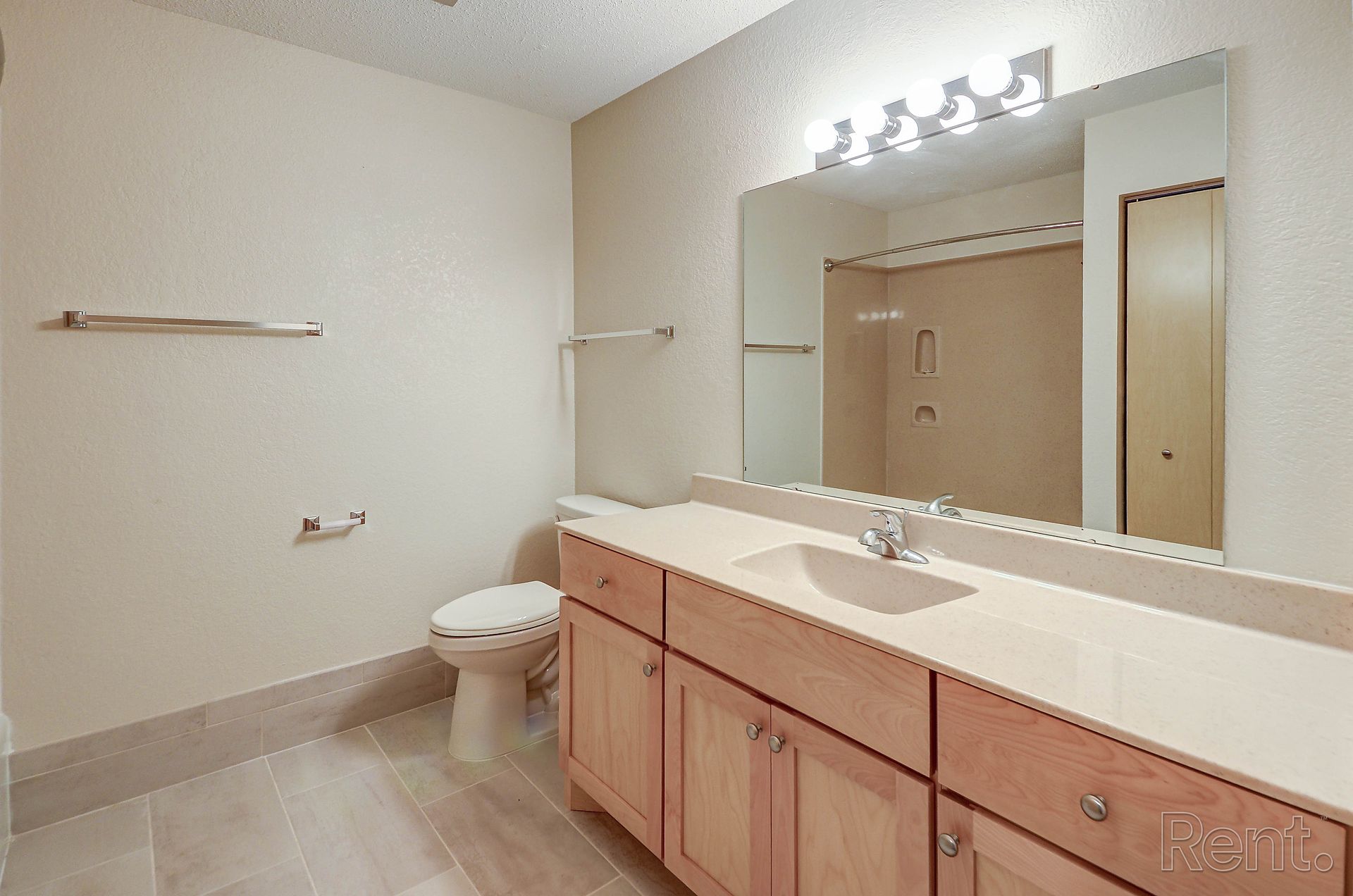 a bathroom with a toilet , sink and mirror