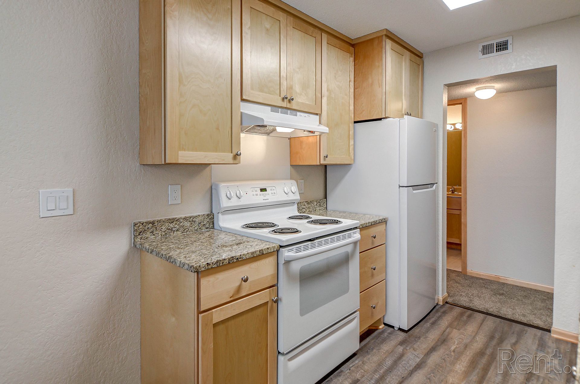 a kitchen with a stove , refrigerator , and cabinets .
