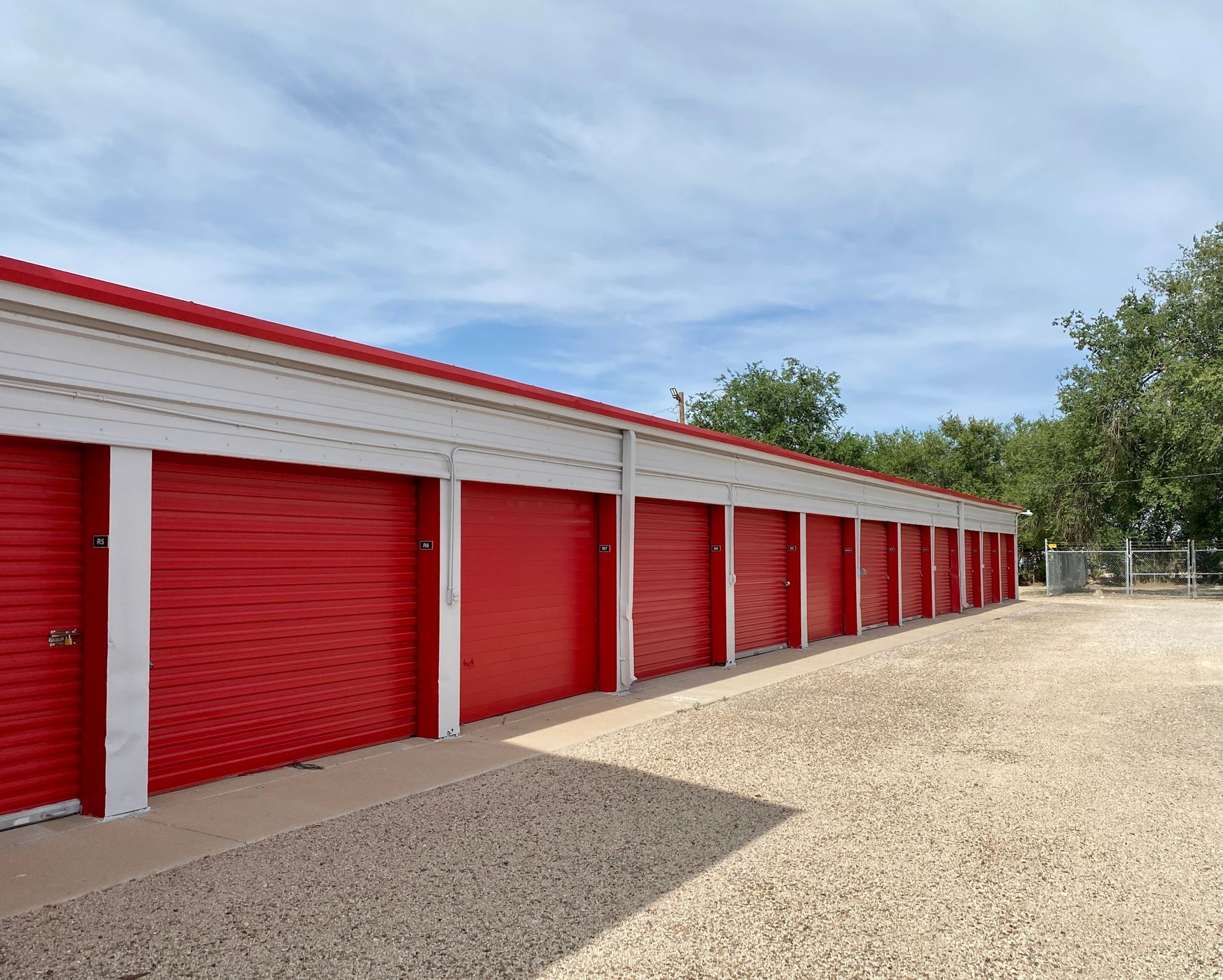 Outdoor storage facility in Hobbs, New Mexico, red and white building, self storage units under a blue sky
