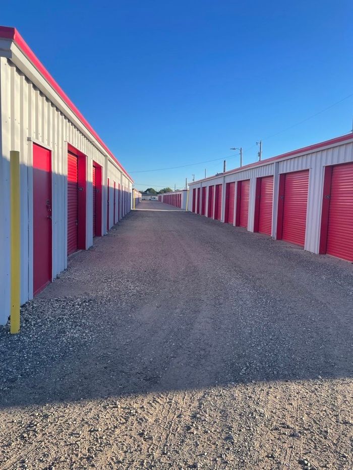 Storage units in Hobbs NM under blue sky, with gravel