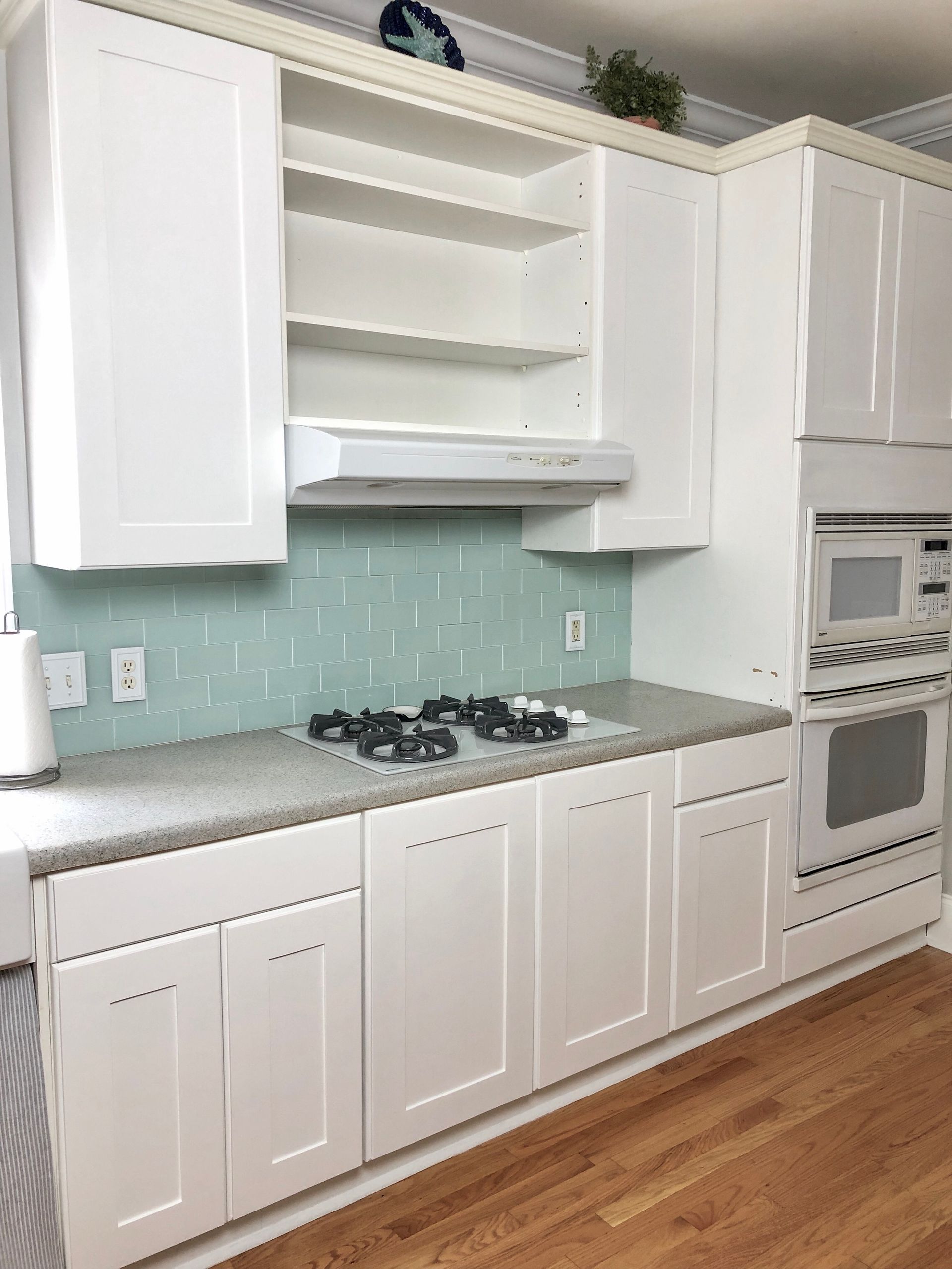 a kitchen under construction with white cabinets and wooden drawers