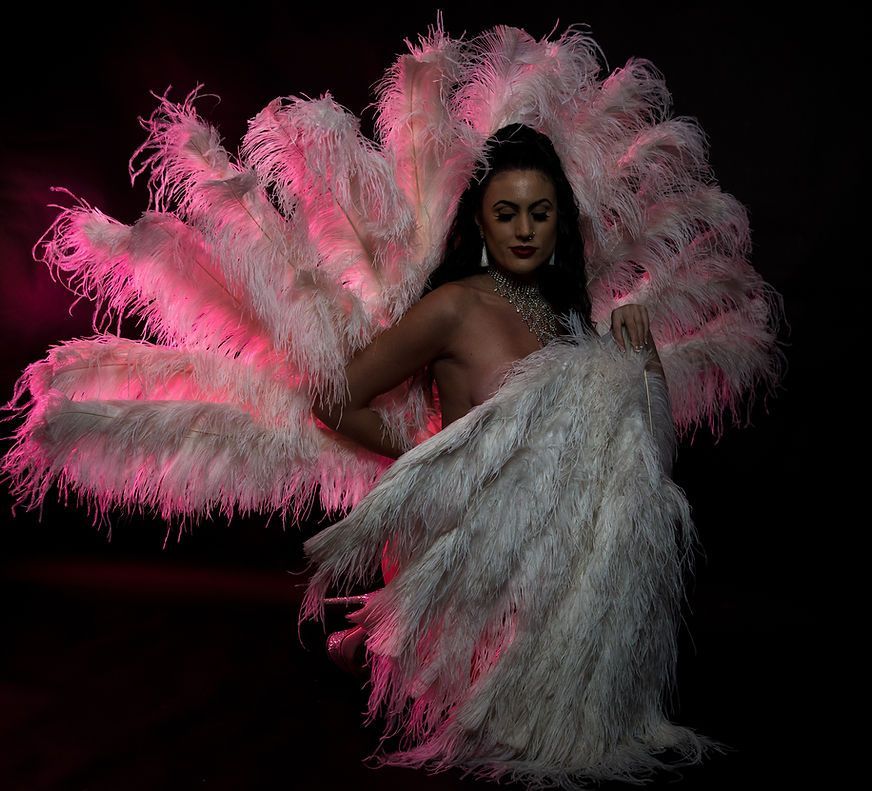 A Woman Is Wearing A Large White Feathered Costume