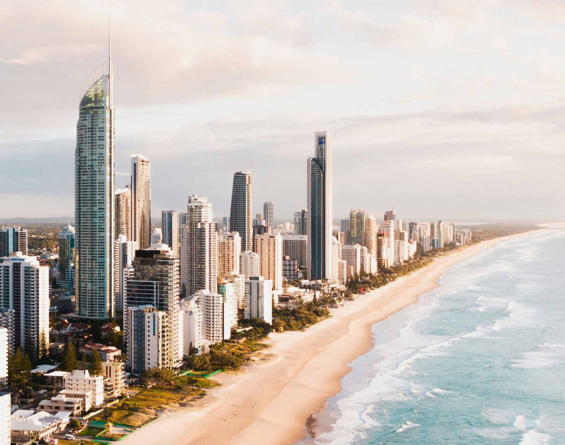 An aerial view of the Gold Coast skyline with a beach in the foreground.