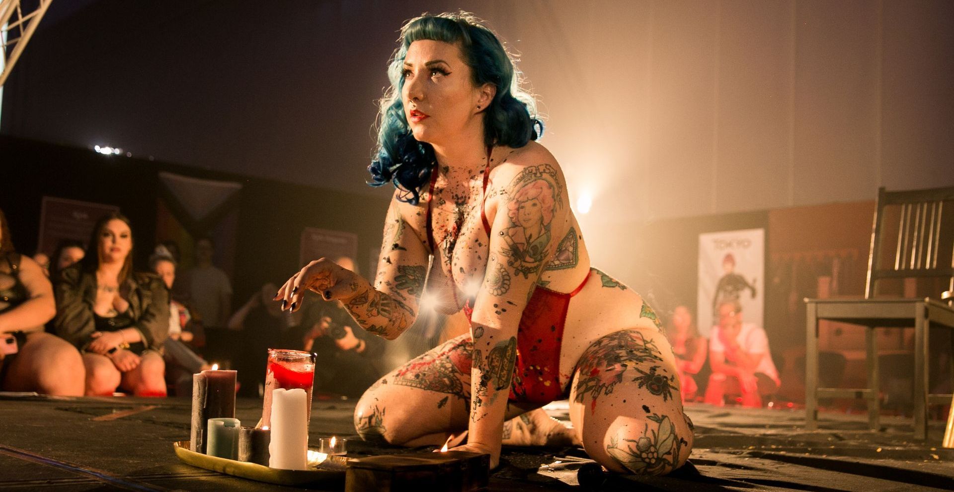 Female performer on a stage playing with wax candles