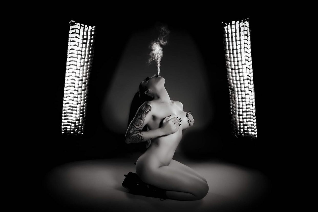 A Woman With Tattoos Blowing Smoke — Celeste Agency in Brisbane, QLD