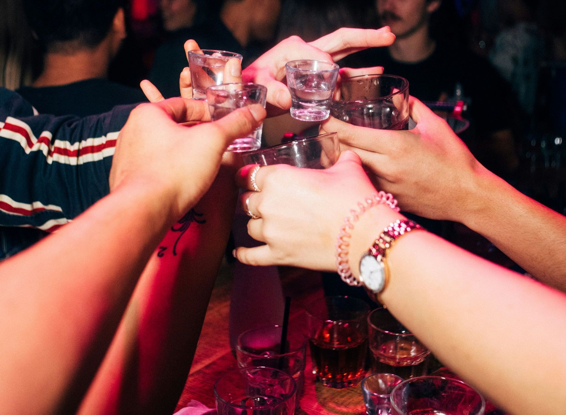 Men at a party cheering with shot glasses.