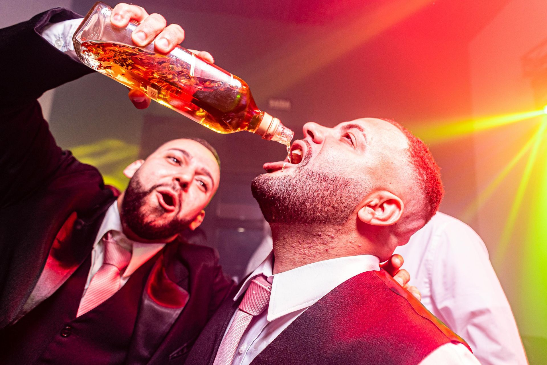 Men celebrating at Brisbane bucks party with alcohol before hiring strippers.