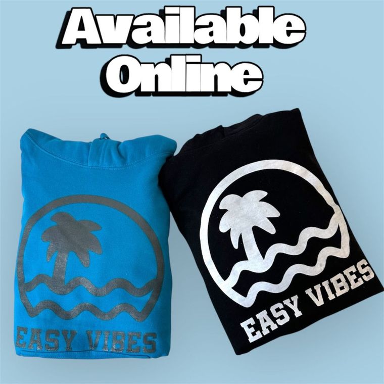 Two folded Easy Vibes shirts, one bright blue the other black, with words above saying 