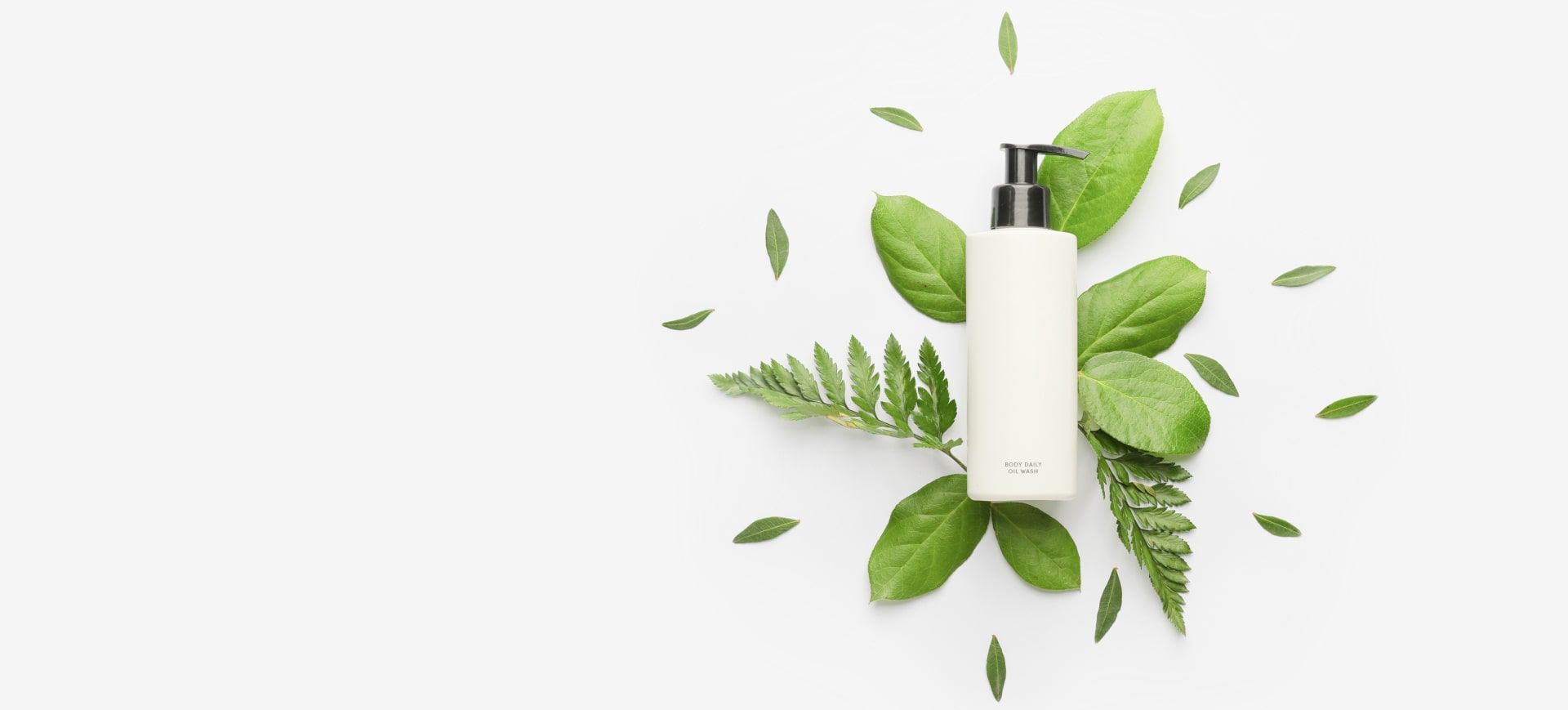 A white bottle surrounded by green leaves on a white background.