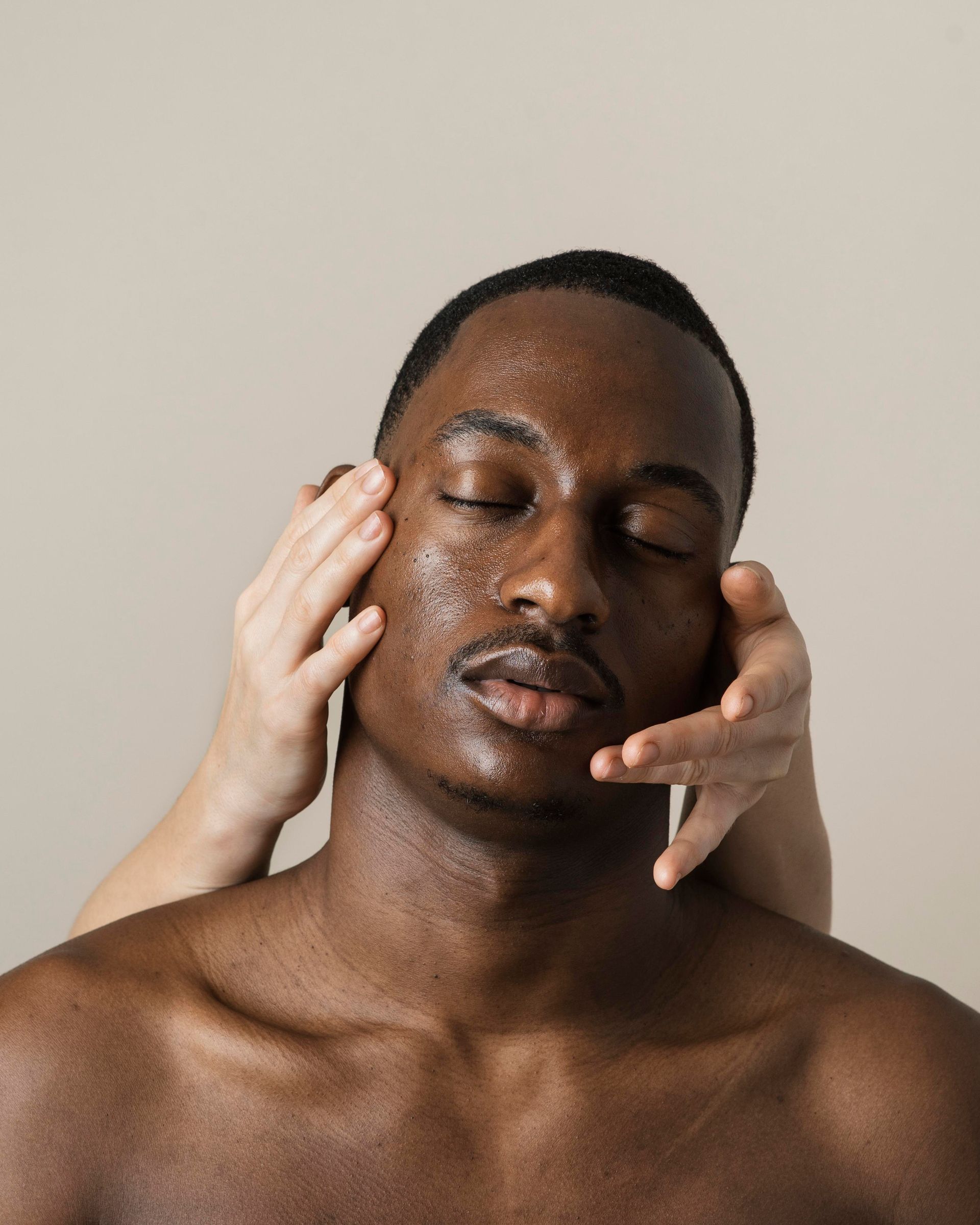 A woman is applying lotion to her shoulder.