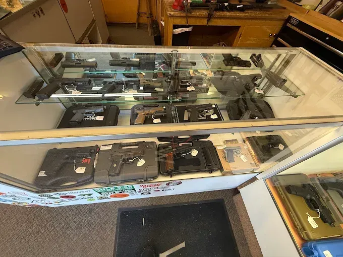 Gun display case in a store, filled with various handguns for sale.