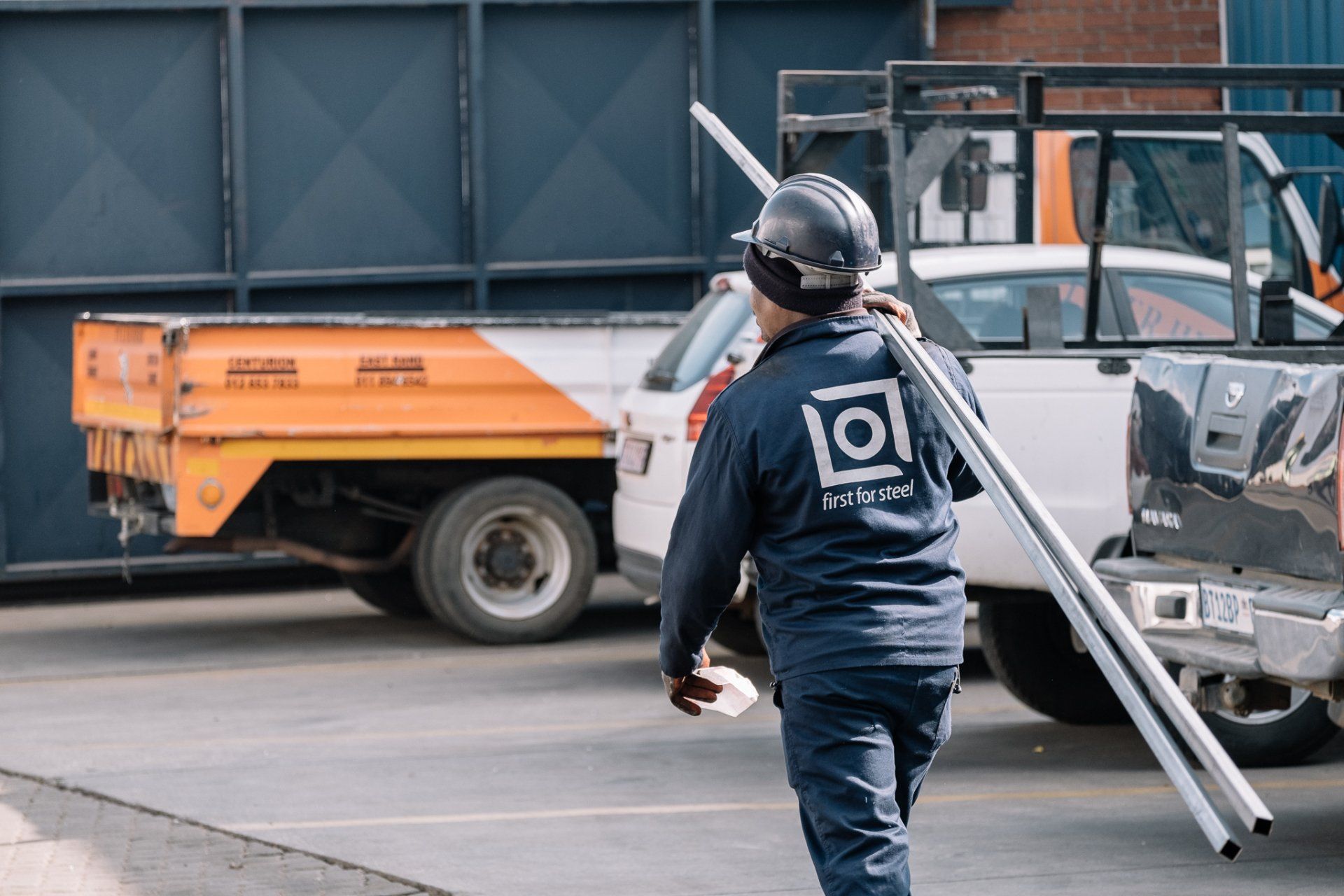 worker carrying njr steel to delivery vehicle