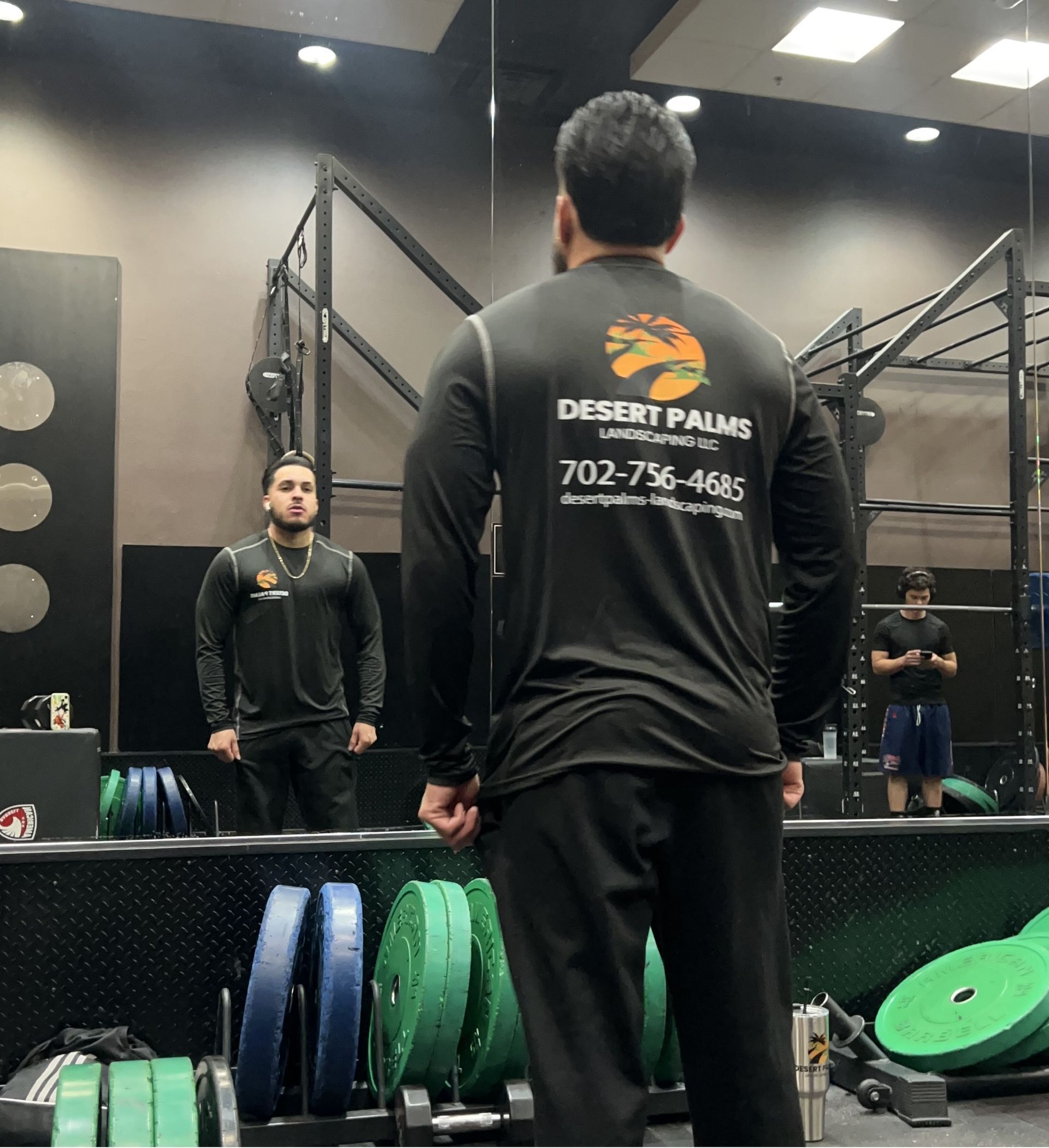Man in gym, looking in mirror, wearing 
