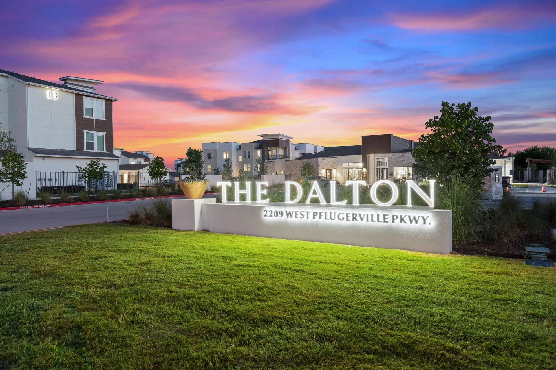 Exterior entrance sign for The Dalton apartment community with landscaping and modern buildings in the background.