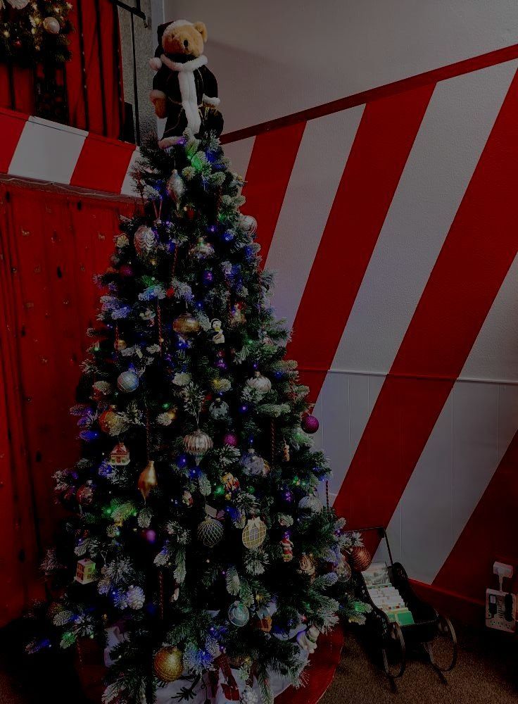 A christmas tree with a teddy bear on top of it