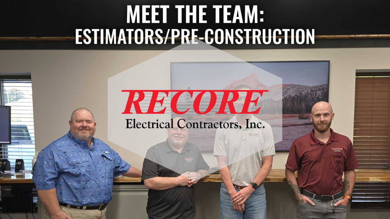 Four RECORE Electrical Contractors employees standing in an office under a team sign